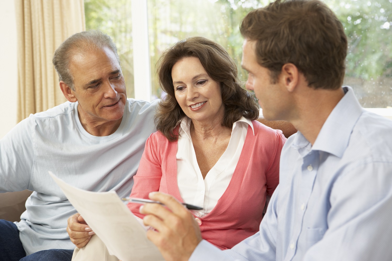 Three people looking over a long-term care insurance
	    policy
